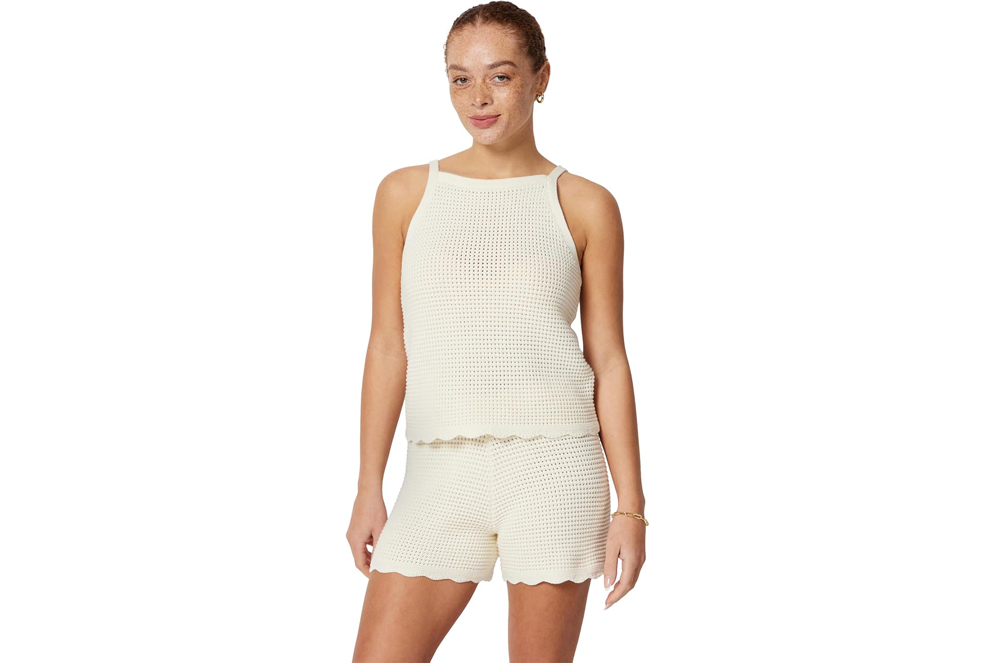 Woman in a white knitted tank top and matching shorts.