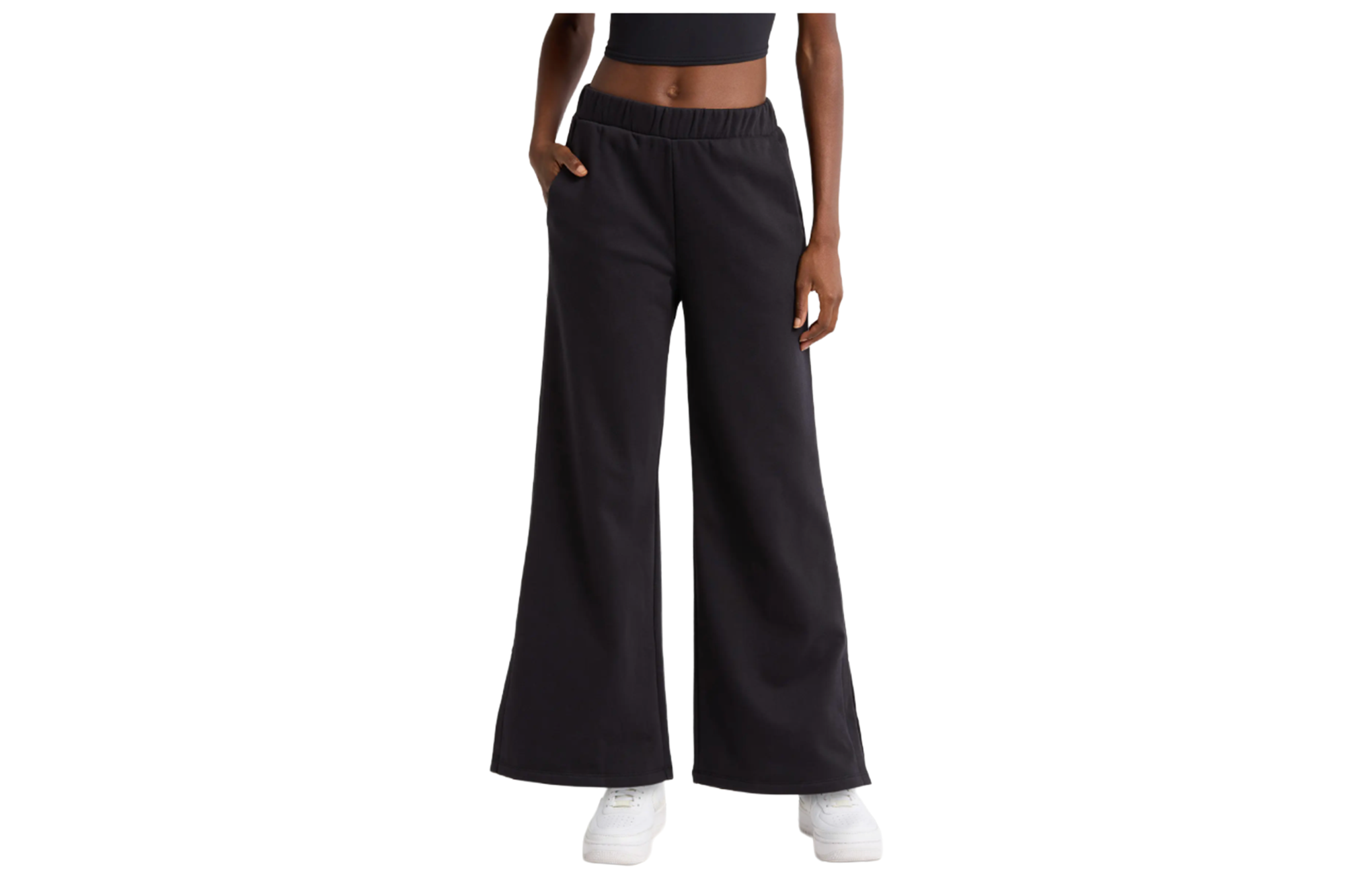 A person wearing black wide-leg sweatpants and a black crop top.
