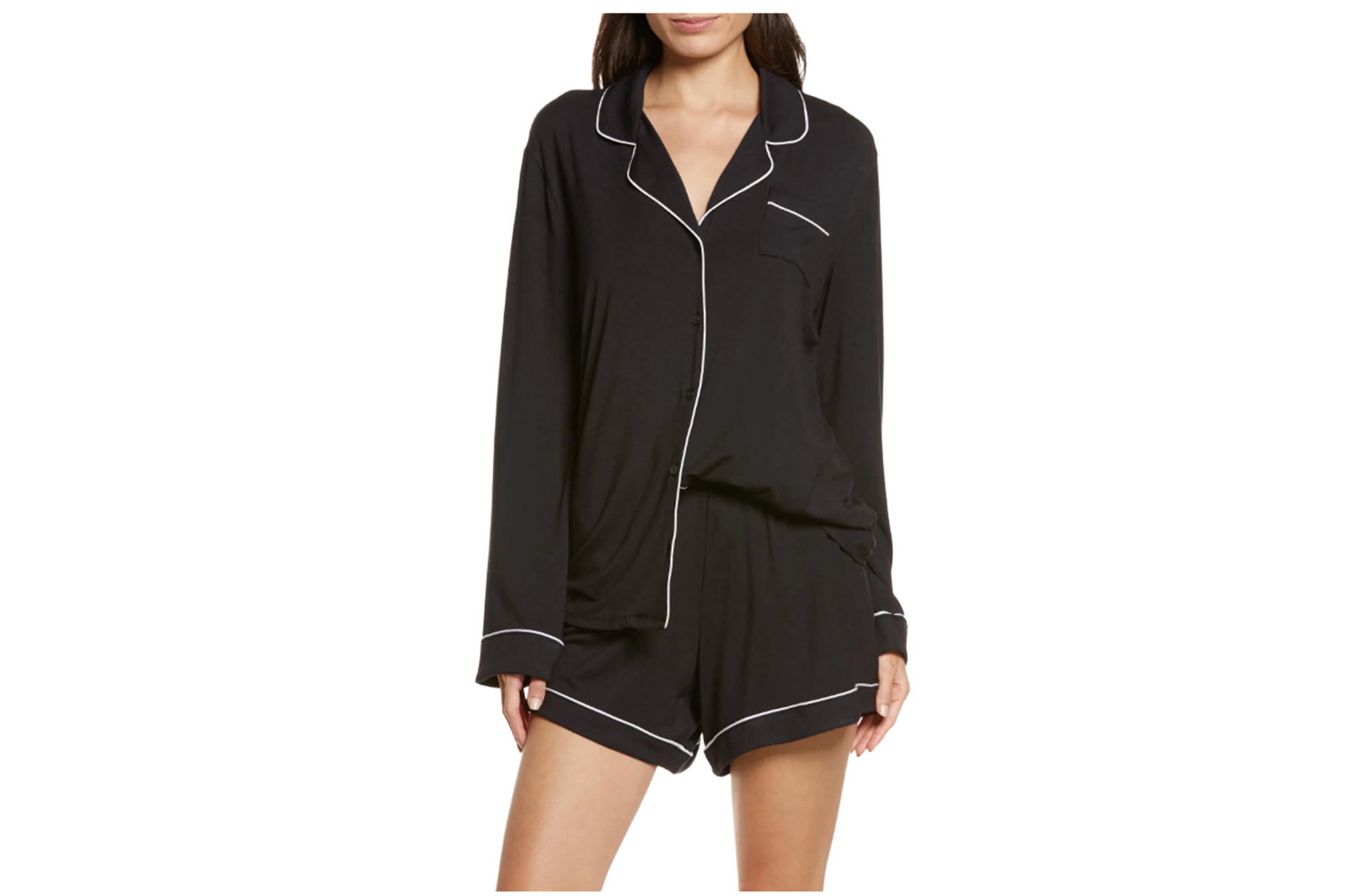 A woman wears black short pajamas with white piping.