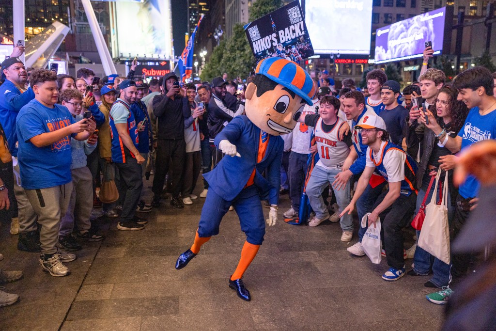 Knicks fans celebrate victory at Madison Square Garden with a mascot.