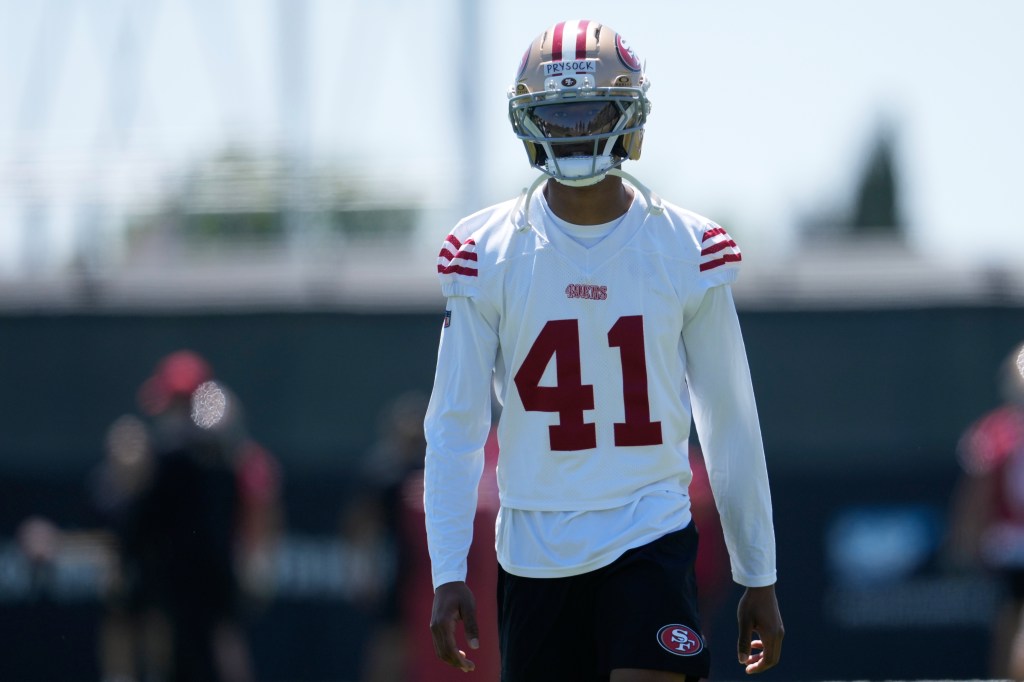 Ephesians Prysock in a white 49ers jersey with the number 41 and a gold helmet.