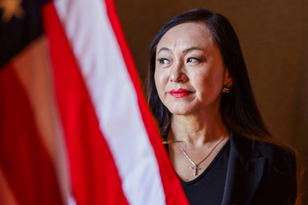 Arcadia council member Eileen Wang looking to the left with an American flag partially visible.