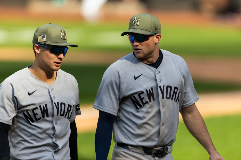 New York Yankees players Anthony Volpe and Max Schuemann walking off the field after a loss.